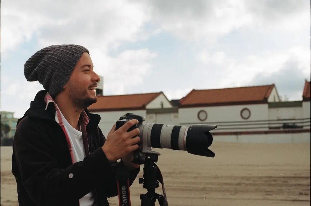 Rodrigo fotografiando en la playa con una Canon sobre trípode